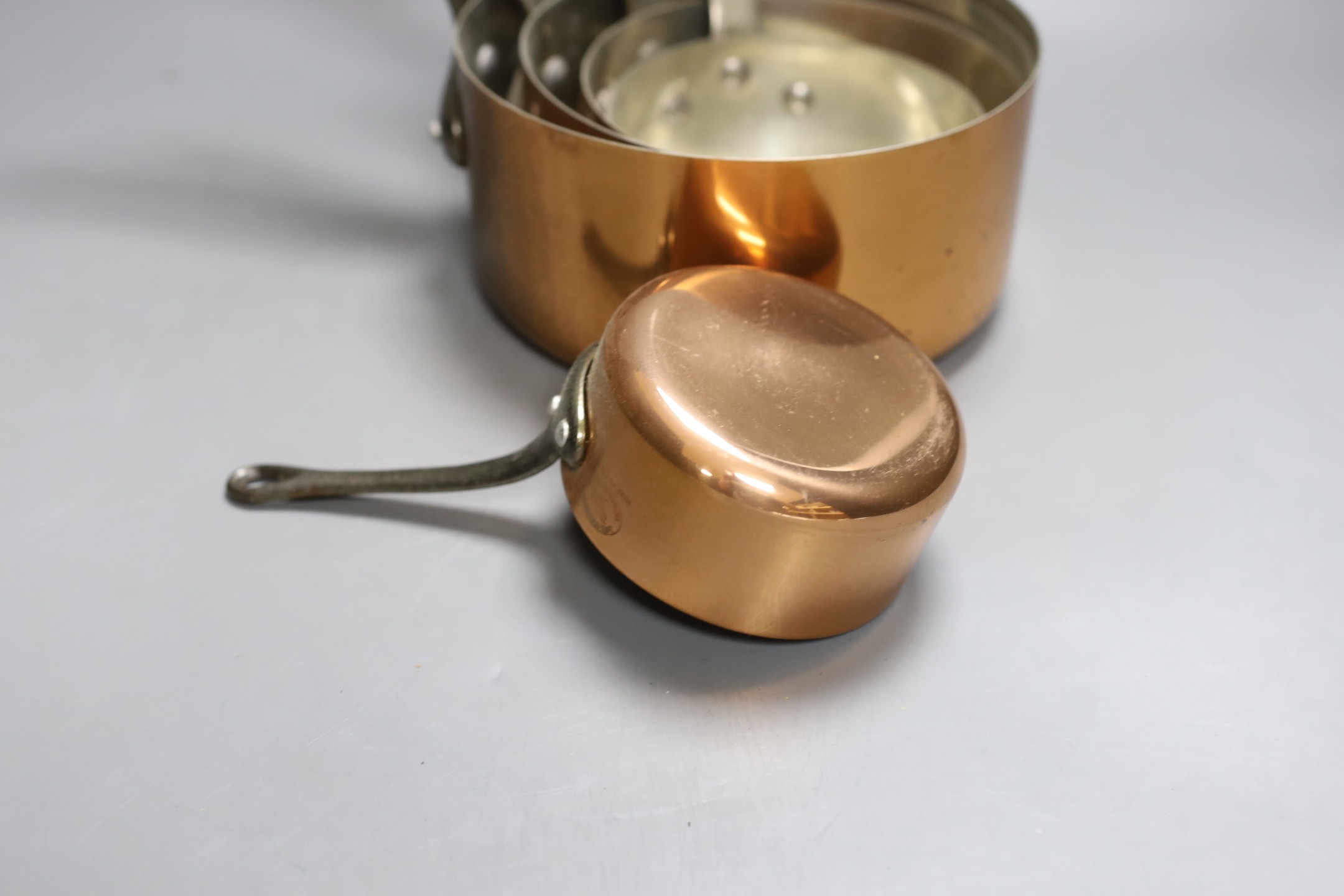 A set of 5 graduated Faucogney copper saucepans